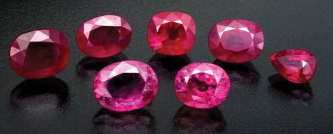 Faceted Mozambique rubies, showing three unheated stones (back row) and two heated gems (front row).